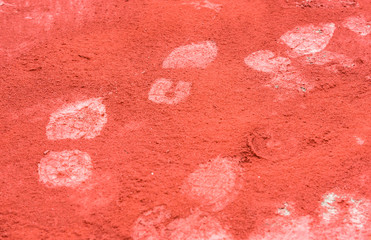 Impronte di scarpe da lavoro su polvere rossa