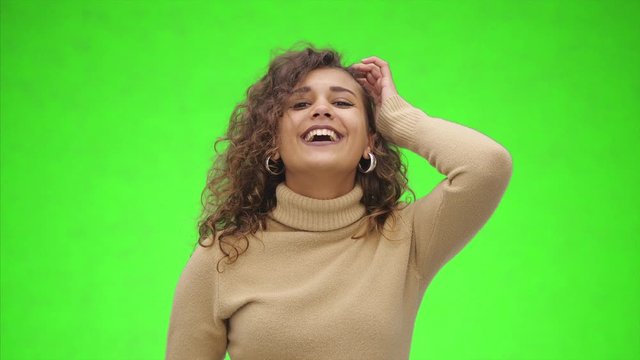 Fave a fun Attractive afro-american girl is playing with her curly hair and showing emotions. Close up. Copy space.