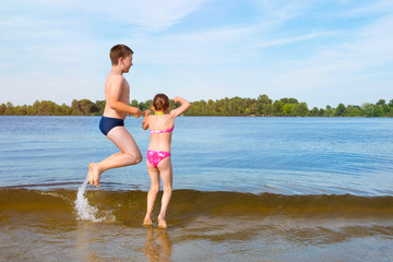 Fototapeta premium Happy kids jumping in the water on a sunny day.