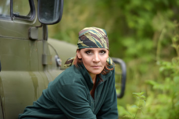 Woman wearing camouflage bandana against the backdrop of UAZ.