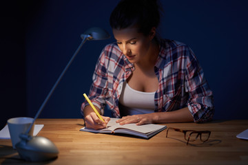 Tired female student learning till late at home
