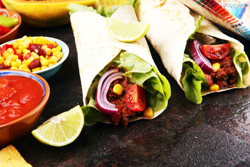 Mexican food, including tacos, guacamole, nachos and pepper on rustic table