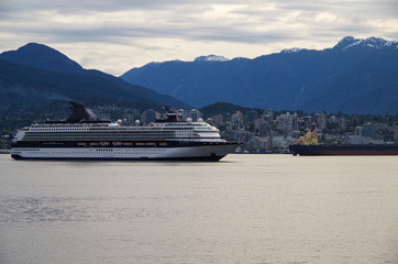 Luxury cruise ship liner in port of Vancouver, Canada with mountains and skyline and snow in the...