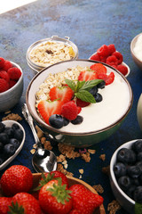 Tasty homemade granola served on table. Healthy breakfast with a bowl of oatmeal with banana, blueberries, strawberries and healthy food for Breakfast
