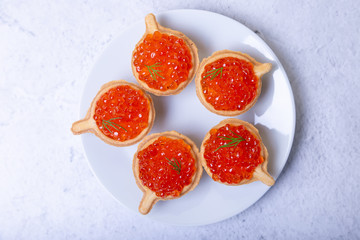 Red caviar (salmon caviar) in tartlets. Selective focus, close-up, top view.