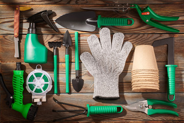 Gardening tools on wooden background flat lay