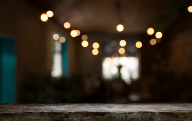 Fototapeta na wymiar Empty wood table top on blur light gold bokeh of cafe restaurant in dark background