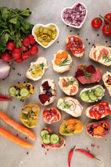 Assorted bruschetta with various toppings. Appetizing bruschetta or brie crostini. Variety of small sandwiches. Mix bruschetta on table