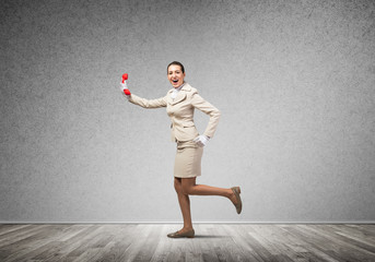 Woman running in room with vintage red phone