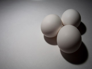 Three white chicken eggs. Easter holiday. Copy space