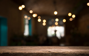 Empty wood table top on blur light gold bokeh of cafe restaurant in dark background