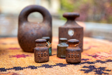 Closeup of rusty metal weights of various shapes and weights close up on a blurred background