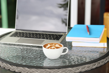 Cups of latte coffee with laptop working in coffee shop