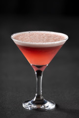 Classic Clover Club cocktail in a cocktail glass on a dark background.