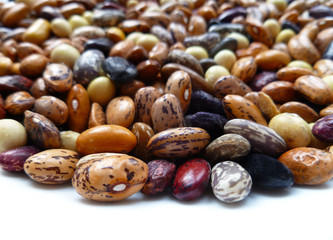 Beans dry mix. Assorted dried beans close up. Variety of protein rich colorful raw dried beans. Multicolored mixed dried beans on white background. Closeup, selective focus