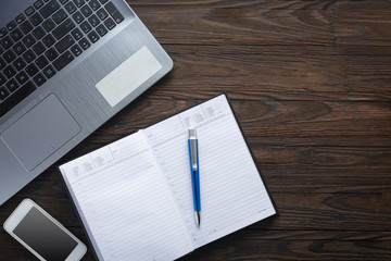 Laptop and notepad on the office desk. Flat lay, top view.