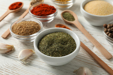 Bowls with spices and ingredients on wooden background, close up