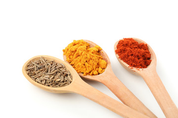 Wood spoons with red pepper, caraway and turmeric  isolated on white background