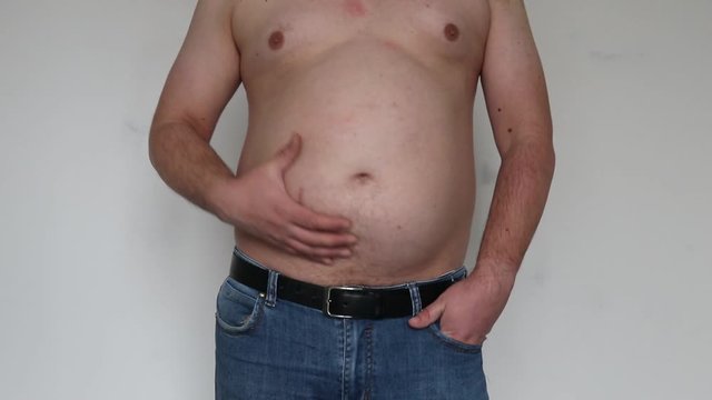 man shakes creases on his stomach. Close-up. On white background.