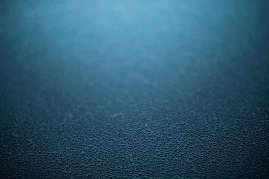 Condensation drops on window. Background with gradient stretch dark blue with drops on the window.
