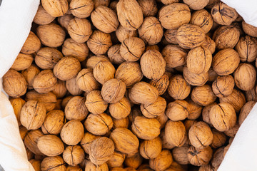 Top view of bag with walnuts in Turkish market. Food background. Lots of walnuts
