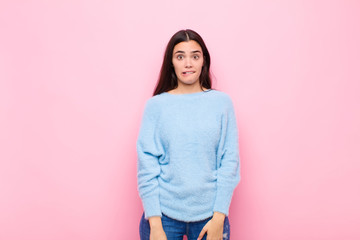 young pretty woman feeling clueless, confused and uncertain about which option to pick, trying to...