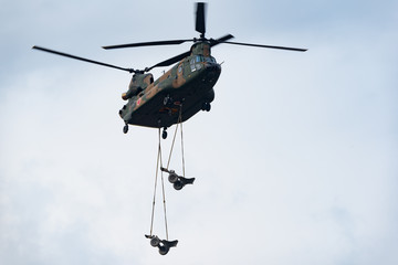 Fototapeta na wymiar 迫撃砲を吊り下げ輸送するヘリコプター