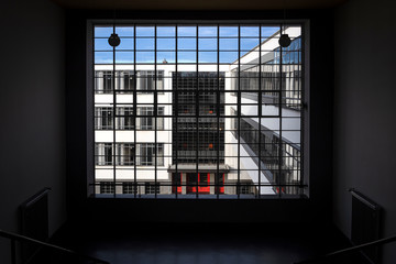Germany, Saxony-Anhalt, Dessau-Rosslau: Bauhaus building seen from inside stairwell through famous glass windows construction with front facade - concept modern architecture art school.