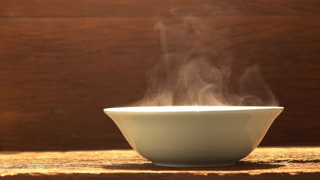 hot bowl with smoke stream on wood table