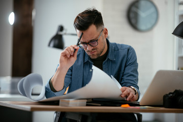 Tired businessman in office. Young architect overworked.