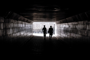 two human silhouettes in the tunel