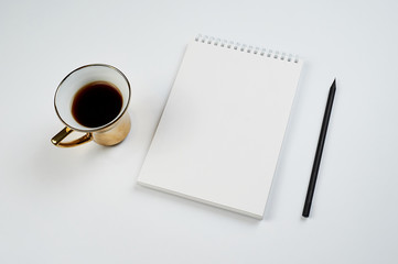 Obraz na płótnie Canvas white office Desk top view with Notepad, pencil and coffee Cup, minimalistic design, top view,copy space,flat lay