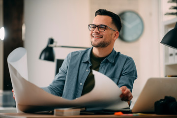 Young businessman working on project. Handsome architect in office.  