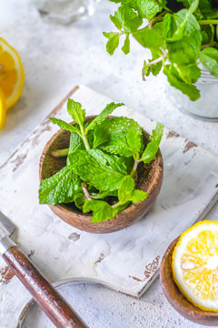 Photo of fresh mint leaves on a cutting board with a knife. Lemon and mint on a cutting board. Peppermint. Ingredients for summer cocktails and lemonade. Macro. Still life. Image.