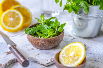 Photo of fresh mint leaves on a cutting board with a knife. Lemon and mint on a cutting board. Peppermint. Ingredients for summer cocktails and lemonade. Macro. Still life. Image.