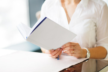 Caucasian business woman in cafe reading book