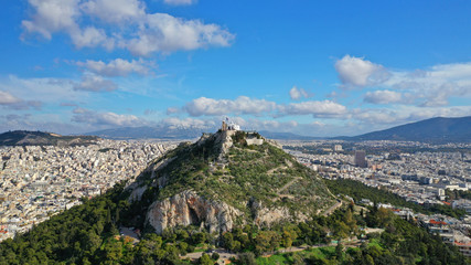 Fototapeta na wymiar Aerial drone photo of iconic chapel of Saint George on top of Lycabettus hill with beautiful deep blue sky and clouds, Athens, Attica, Greece