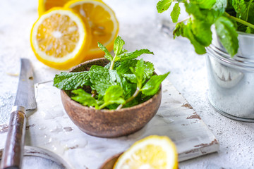 Photo of fresh mint leaves on a cutting board with a knife. Lemon and mint on a cutting board. Peppermint. Ingredients for summer cocktails and lemonade. Macro. Still life. Image.