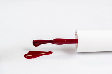 red nail polish and manicure brush with varnish