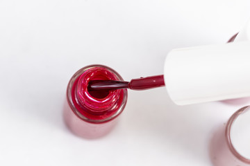 red nail polish and manicure brush with varnish