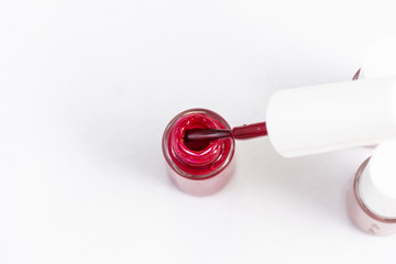 red nail polish and manicure brush with varnish
