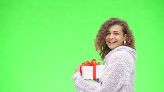 Afro-American woman is recieving a giftbox with red ribbon. Best wishes. Close up. Copy space.