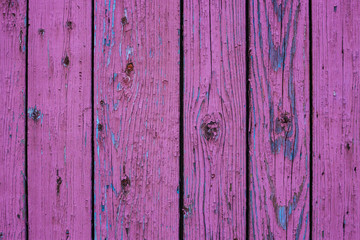 wooden background made of vertical planks with vibrant pink peeled grunge surface