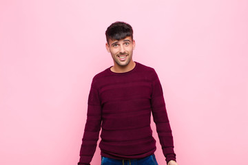 young handsome man with a big, friendly, carefree smile, looking positive, relaxed and happy,...