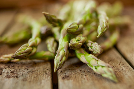 Still life close up fresh, organic, healthy, green asparagus tips on wood