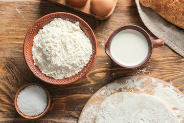 Fototapeta na wymiar Bowl with flour, salt and milk on table