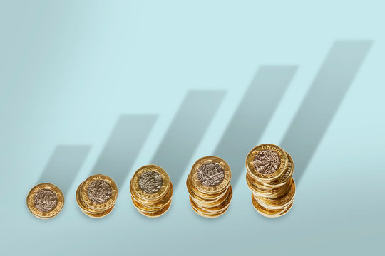 Ascending stacks of pound coins with bar graph growth shadow