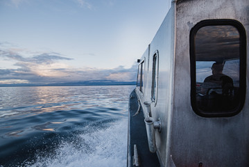 Captain driving boat on tranquil river, Campbell River, British Columbia, Canada