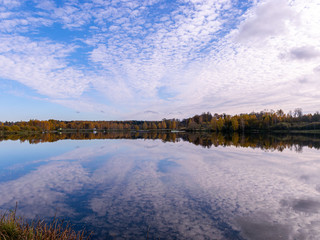 Obraz premium landscape with trees and clouds reflecting in calm water