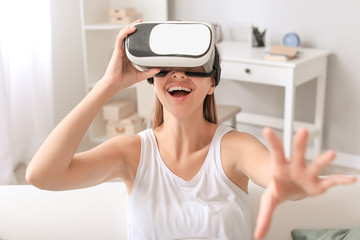 Young woman with virtual reality glasses at home